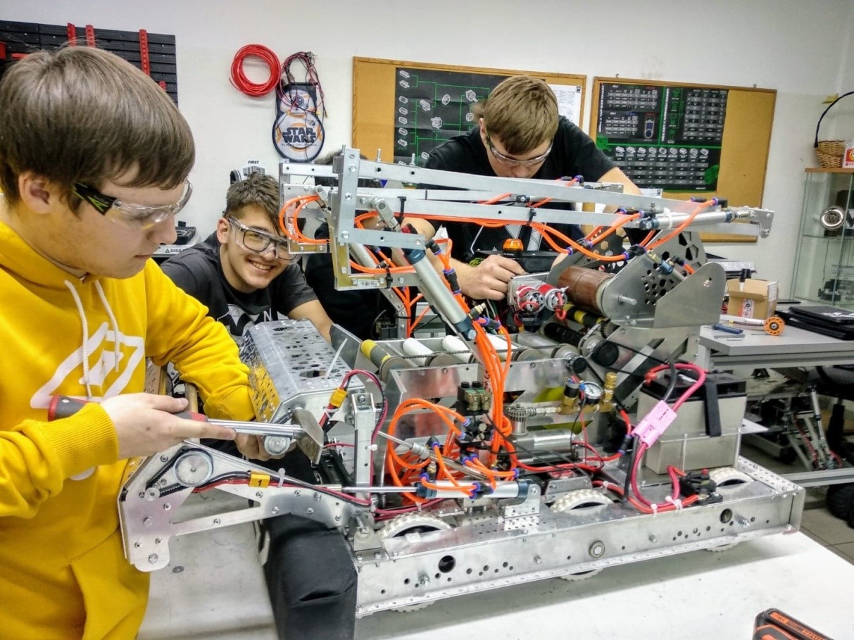 Na zdjęciu uczniowie budują robota w szkolnym warsztacie