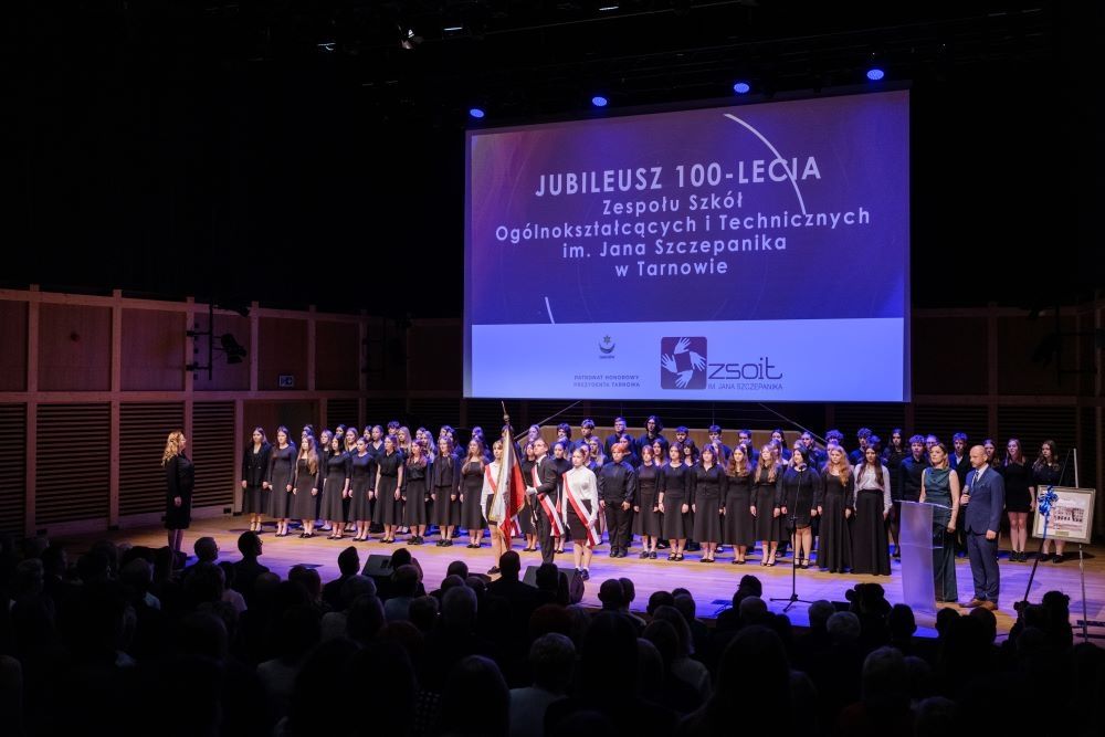 baner informujący o jubileuszu 100lecia szkoły, chór oraz poczet sztandarowy