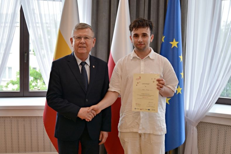 marszałek podaje rękę /gratuluje uczniowi